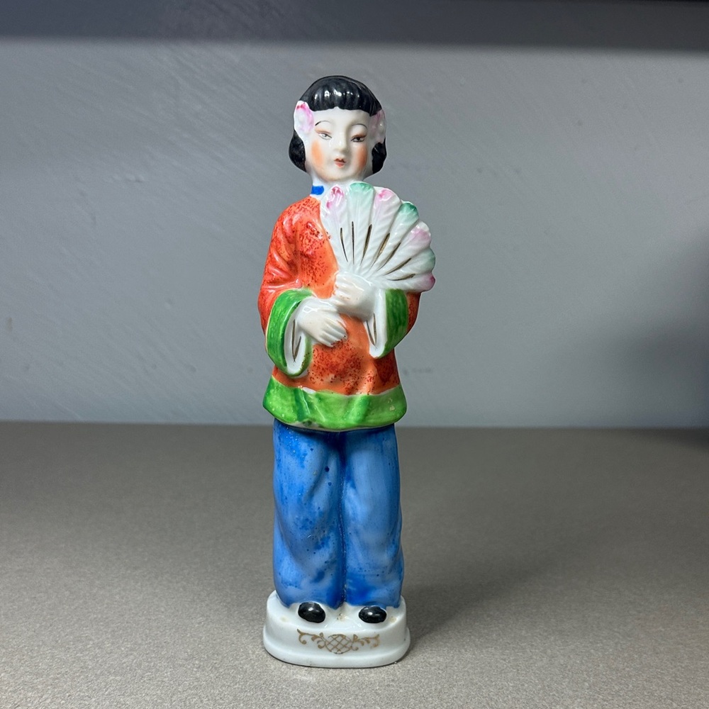 Ceramic hand painted Asian woman in Orange and Blue holding a fan.